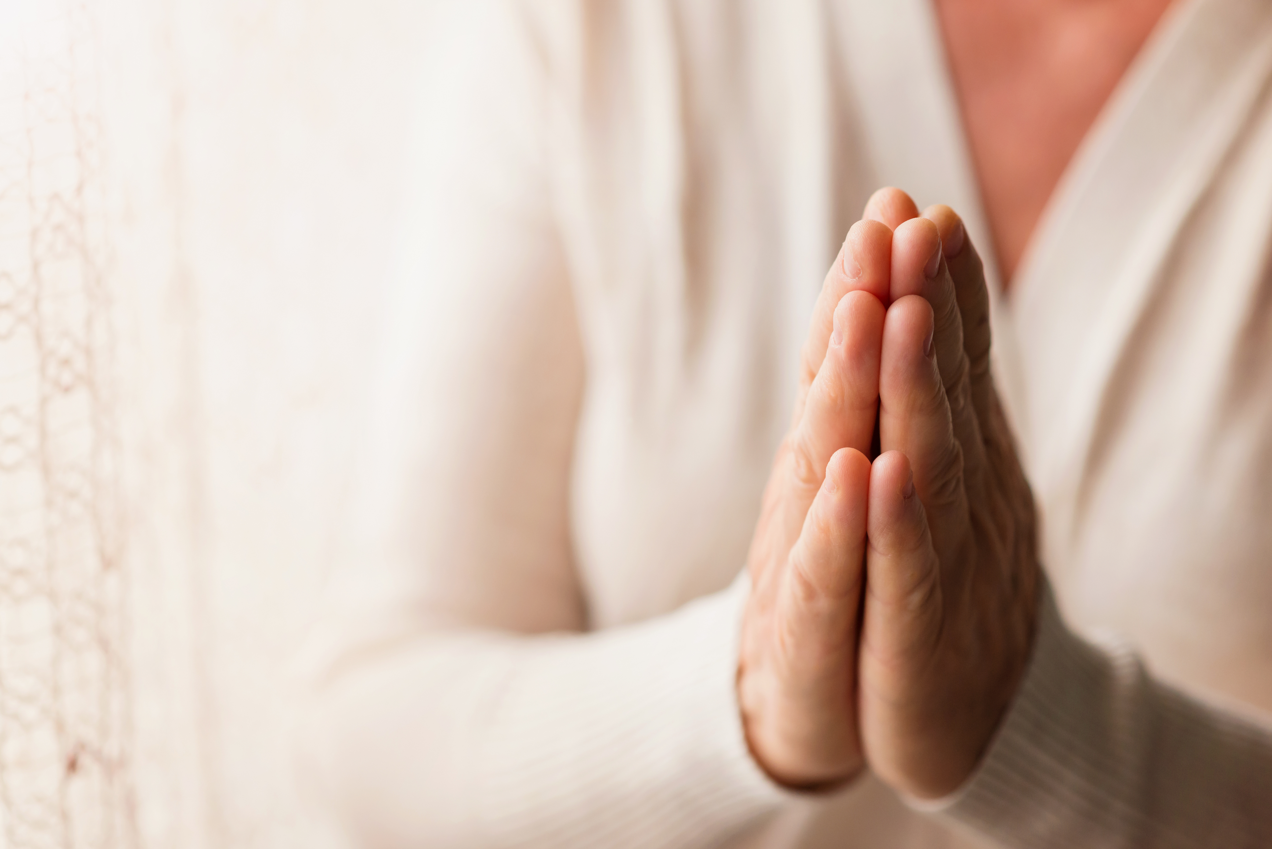 Woman's hands clasped in prayer